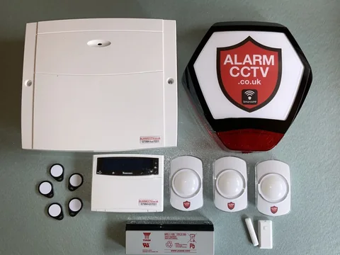 An AlarmCCTV wireless alarm panel, branded sounder and sensors laid out before installation