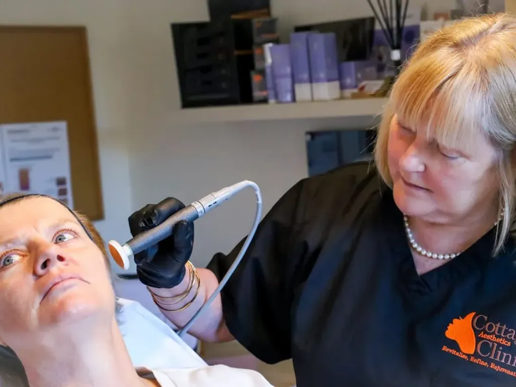 An aesthetic nurse carrying out a treatment on a client at Cottage Aesthetics Clinic