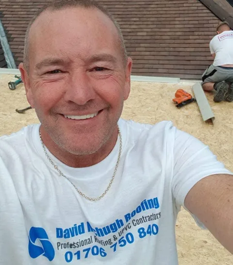 David McHugh on a roof in Rochdale, wearing a David McHugh Roofing branded T-shirt