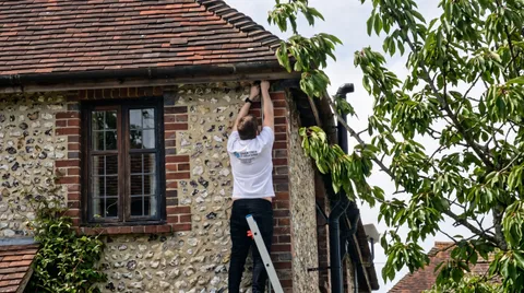A DNGR Tech engineer in branded uniform installing equipment at a customer property