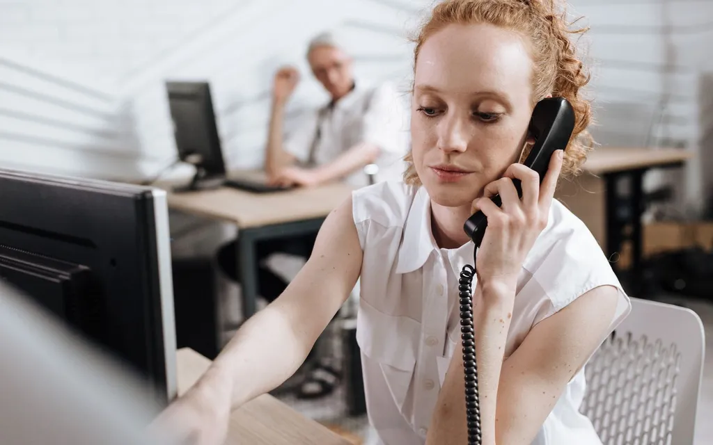 Accountant taking a client call on the office phone while working at her desk