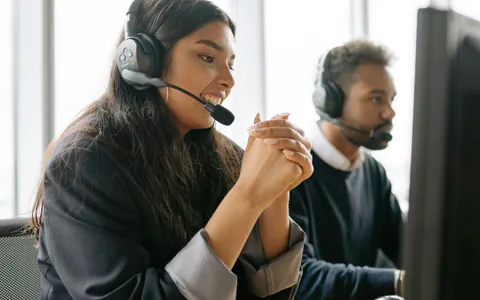 Call centre agents wearing headsets answering calls in a busy office